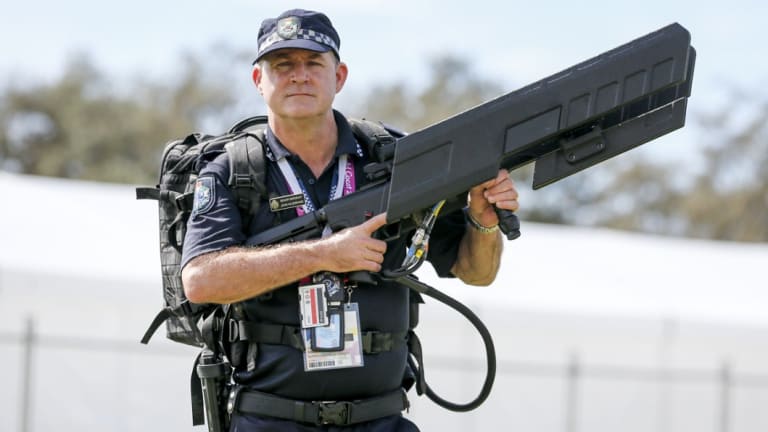 Queensland Police senior sergeant John Hildebrand carrying DroneShield's drone gun, which was used at the Commonwealth Games.