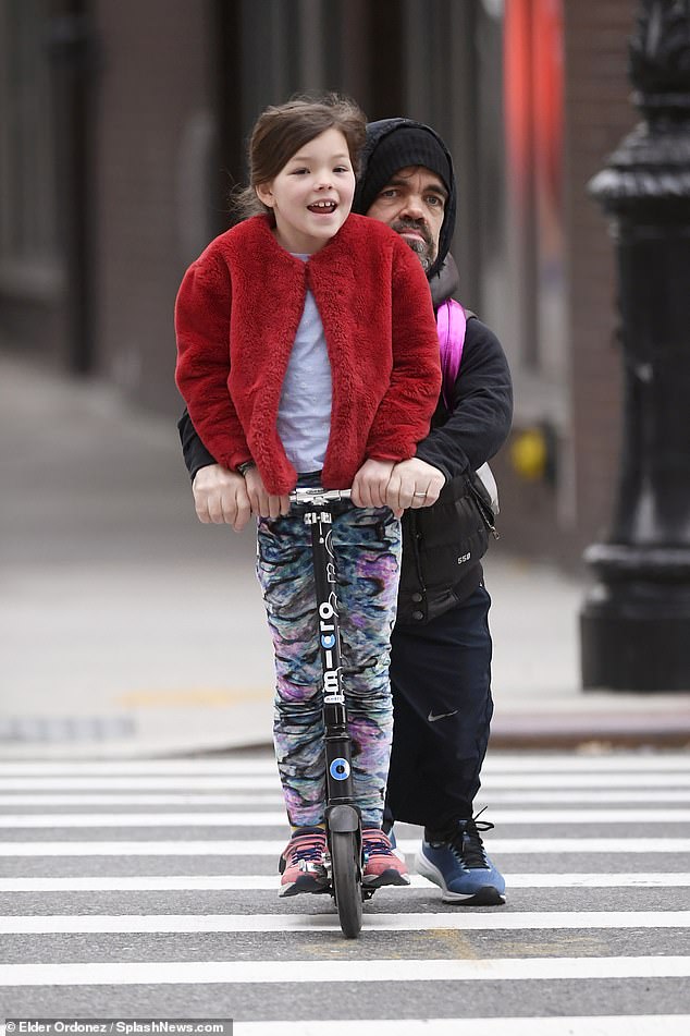 Daddy day care: The Game Of Thrones star held his child close as the two weaved around the streets of the American city