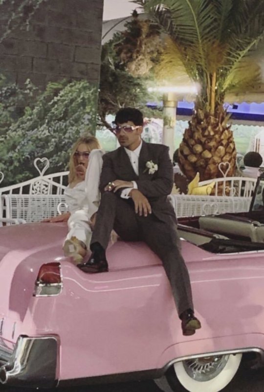 Sophie Turner and Joe Jonas pose on a pink Cadillac after their Las Vegas wedding