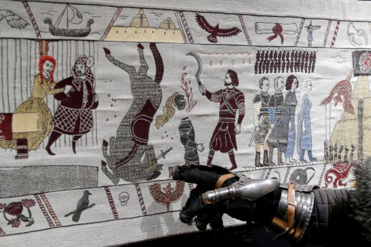 A visitor points at the Game of Thrones Tapestry in Bayeux, France, September 13, 2019. The 87-metre-long tapestry work was made in Northern Ireland to honour the television series Game of Thrones is on display across the street from the better-known original 11th-century Bayeux Tapestry. REUTERS/Charles Platiau NO RESALES. NO ARCHIVES