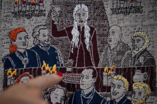 A woman points a starbucks coffee cup reproduced in a section of a 87 meters tapestry relating the 8 seasons of US television series "Game of Thrones" on September 13, 2019 in Bayeux. - Like the Bayeux Tapestry, the Game of Thrones Tapestry is woven of fine linen and hand-embroidered, with decorative borders and a central pictorial narrative. (Photo by LOIC VENANCE / AFP)LOIC VENANCE/AFP/Getty Images