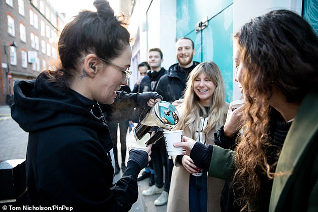 Warm: She wore a Choose Love hoodie over a t-shirt and cosy winter undergarment, pulling on the sleeves so they covered her hands as she handed out hot drinks on Friday