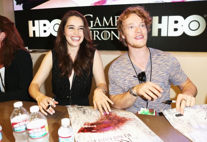 Emilia Clarke and co-star Alfie Allen sign autographs for "Game of Thrones" during Comic-Con International in 2012.