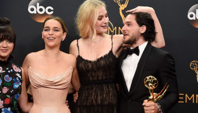 The Game of Thrones cast poses with an Emmy award.