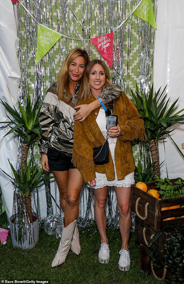 Fun times: Laura looked stunning as she enjoyed herself in the Fatty's Organic Spirits tent wearing a shiny silver bomber jacket with a white 'V' shape around the neck
