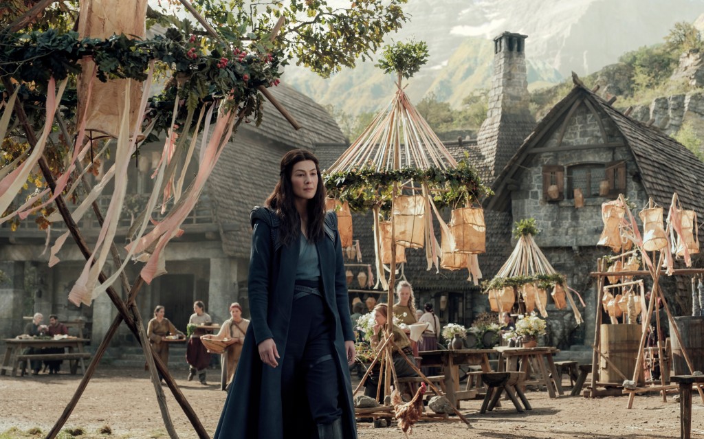 Rosamund Pike stands on a medieval village set in "The Wheel of Time." 