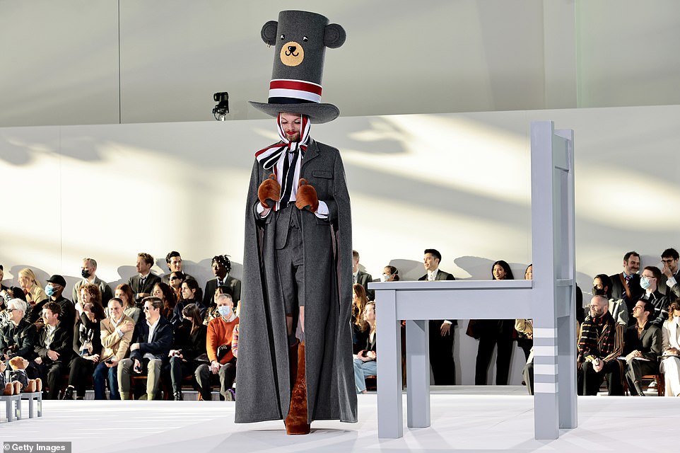 Playful: One model had on a traditional gray overcoat, but with brown suede boots and a massive charcoal top hat with a teddy bear drawn on it