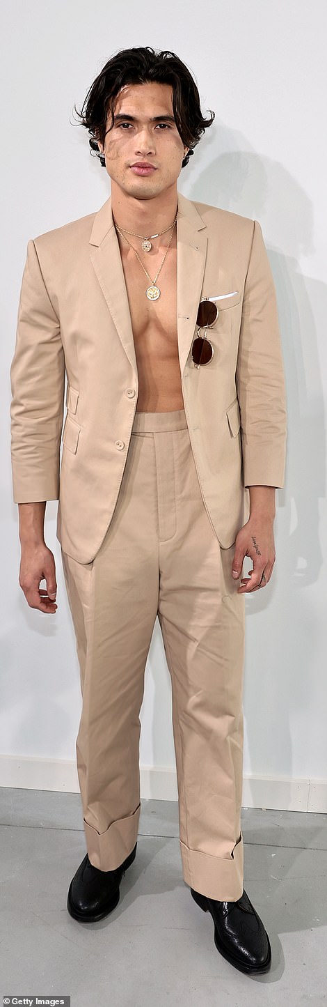 Works out: Charles Melton couldn't help but show off his impressive abs in a tan blazer that he wore without a shirt, along with pants in the same shade with tall cuffs and black leather shoes