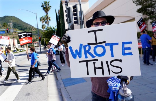 Justice Hardy holds up a sign during the WGA writer strike